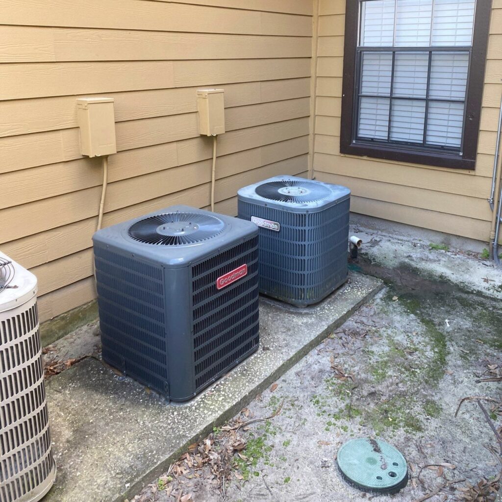 Two outdoor AC units beside a home